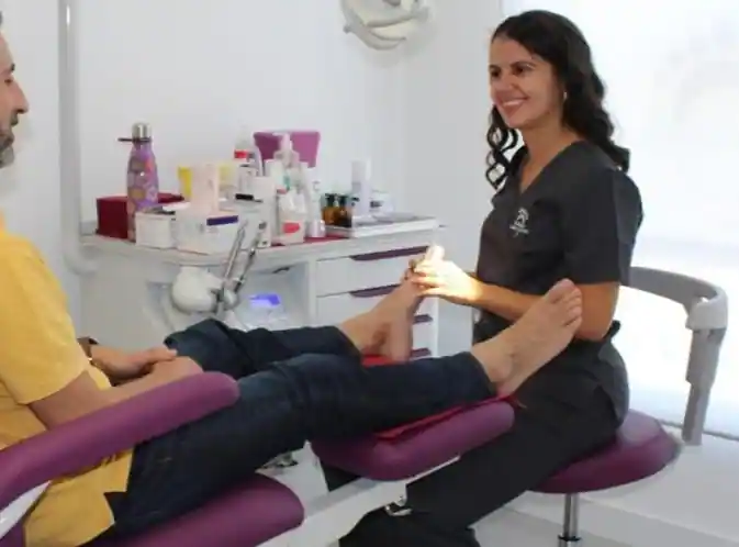 Podóloga realizando una consulta a hombre.